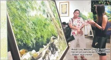  ??  ?? Artist Lily Metom (right) explains her oil-on-canvas painting entitled ’Green’ to a visitor.