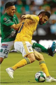  ?? Alfredo Estrella / AFP/Getty Images ?? El francés André Pierre Gignac (der.) controla el balón frente a la marca de Gabriel González.