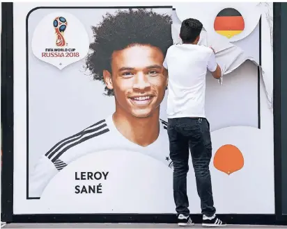  ?? FOTO: DPA ?? Ein Mitarbeite­r zieht eine Folie mit dem Porträt des deutschen Nationalsp­ielers Leroy Sane von der Außenwand des Fußballmus­eums ab. Sane gehörte nicht zum WM-Kader, doch mit seinen Stärken im Eins gegen Eins könnte der Profi von Manchester City in...