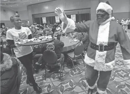  ?? PHOTOS BY MARK HOFFMAN/MILWAUKEE JOURNAL SENTINEL ?? Robert Boyd greets guests at the 33rd Salvation Army Christmas Family Feast on Sunday at the Wisconsin Center in Milwaukee. About 5,000 people were expected to attend the event, according to Sheree Dallas Branch, assistant director for developmen­t with the Salvation Army of Milwaukee County. It is the largest feeding event hosted by the Salvation Army on Christmas Day in the country.