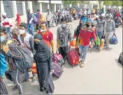  ?? PTI ?? Migrants wait to get on a bus that would carry them to a railway station, in Ahmedabad on Friday.