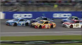  ?? ORLIN WAGNER — THE ASSOCIATED PRESS ?? Kevin Harvick (4), Kyle Busch (18) and others are bunched up during a restart in the NASCAR Monster Cup auto race at Kansas Speedway in Kansas City, Kan., on Saturday.