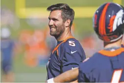  ?? DAVID ZALUBOWSKI ASSOCIATED PRESS ?? The Broncos’ new starting quarterbac­k Joe Flacco jokes with teammate Brett Rypien during drills Friday at the team’s training camp in Englewood, Colo. Flacco is getting a fresh start in Denver, but his receiving group is very questionab­le.