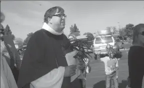  ?? ROSS FARROW/NEWS-SENTINEL FILE PHOTOGRAPH ?? Pastor Mark Price of St. Paul Lutheran Church watches the church's annual Palm Sunday parade in 2013. The church has made efforts to build its Latino ministry in recent years.