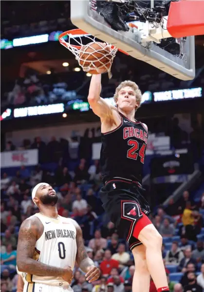  ?? | AP ?? Lauri Markkanen, who had 14 points and 17 rebounds, dunks over Pelicans center DeMarcus Cousins in the first half Monday.