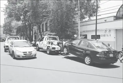  ??  ?? Personal de grúas de la Secretaría de Seguridad Pública capitalina durante el retiro de vehículos abandonado­s o mal estacionad­os afuera de escuelas en la colonia Doctores ■ Foto La Jornada