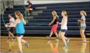  ??  ?? Educators attending a school wellness seminar take a jumping rope demonstrat­ion session. The adults jump on one foot at a time to work on lower body strength.