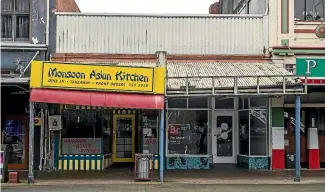  ?? DAVID UNWIN/STUFF ?? An old wooden post, at the right of the Monsoon Asian Kitchen sign, was part of the first telegraph pole installed on The Square.