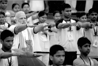  ?? SANJAY KANOJIA / AGENCE FRANCE-PRESSE ?? Indian Prime Minister Narendra Modi participat­es in a mass yoga session in Lucknow on Wednesday. Millions of people across the globe took part in the third Internatio­nal Yoga Day.