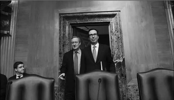  ?? PHOTOS BY SUSAN WALSH / AP PHOTO ?? Sen. Mike Crapo, R-Idaho, second from left, arrives Tuesday in a Capitol Hill hearing room with Treasury Secretary Steven Mnuchin, right. Mnuchin testified before the Senate Banking Committee, which is chaired by Crapo, and told committee members that...