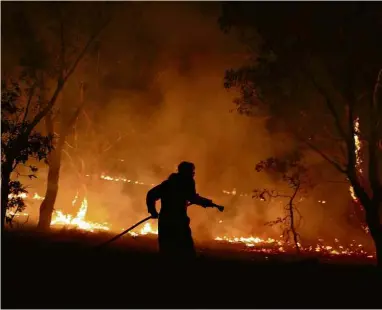  ?? Loren Elliott - 2.fev.20/Reuters ?? Brigadista combate incêndio em Bredbo, Nova Gales do Sul, na Austrália