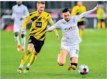  ?? FOTO: MARTIN MEISSNER/AP ?? Für Dortmunds Marco Reus (l.) ist es ein gebrauchte­r Abend, Gladbachs Ramy Bensebaini dagegen bringt sein Team mit dem Treffer zum 3:2 auf die Siegerstra­ße.