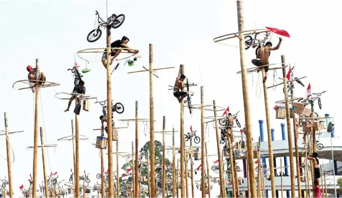  ??  ?? Participan­ts climb greasy poles at a beach in Jakarta yesterday, during Panjat Pinang, a pole climbing contest to celebrate Indonesia’s 74th anniversar­y of independen­ce from Dutch rule. — AFP