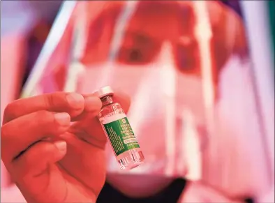  ?? Getty Images ?? A health worker shows a vial of Covishield, AstraZenec­a-Oxford’s COVID-19 coronaviru­s vaccine made by local partner Serum Institute of India, at Patan Hospital near Kathmandu on Wednesday.