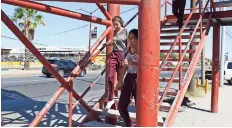  ??  ?? dos niñas cruzan por un puente peatonal