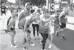  ?? REINHOLD MATAY/ORLANDO SENTINEL ?? Local runners take a selfie with athletes from as far away as Japan as they participat­e the OUC 13.1 half marathon on Saturday in Orlando. in
