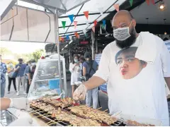  ?? NUTTHAWAT WICHEANBUT ?? Rap singer Natthawut ‘Golf’ Srimok sells grilled pork on skewers to earn income for his family after the outbreak caused his work to dry up.