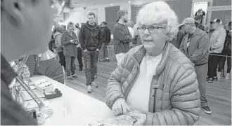  ?? Mathew Sumner photos / Associated Press ?? Margot Simpson purchases marijuana Monday at Harborside marijuana dispensary in Oakland, Calif. Recreation­al marijuana now can be sold legally in California.