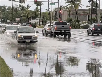  ?? The Maui News / LILA FUJIMOTO photo ?? Vehicles make their way through a flooded portion of Dairy Road at Hana Highway on Monday morning. About 2 feet of water collected in the roadway. A National Weather Service flash flood watch for Maui County remained in effect through this afternoon.