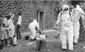  ?? JOHN BOMPENGO / ASSOCIATED PRESS ?? Health officials prepare to disinfect people and buildings at the general referral hospital in Mbandaka, the Democratic Republic of Congo, on May 31.