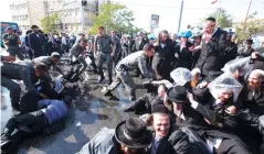  ?? (Marc Israel Sellem/The Jerusalem Post) ?? BORDER POLICE OFFICERS detain ultra-Orthodox protesters on Sunday during a draft riot in Jerusalem.