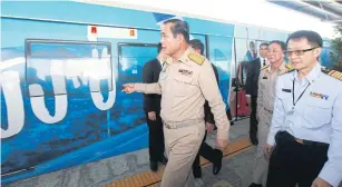  ?? SOMCHAI POOMLARD ?? Prime Minister Prayut Chan-ocha leads officials on a short journey on a section of elevated rail track, linking Soi Bearing and Samrong, during its opening ceremony yesterday.