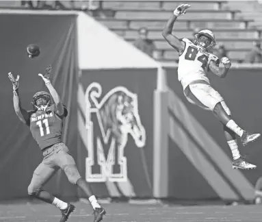  ?? JOE RONDONE/THE COMMERCIAL APPEAL ?? Memphis defender Sylvonta Oliover nearly grabs an intercepti­on beyond the arms of South Florida receiver Xavier Weaver at Liberty Bowl Memorial Stadium on Saturday.