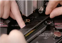  ??  ?? It helps to have a friend hold the SSD flat while you pay attention to lowering the shield over it and carefully aligning and tightening the screws. Feel free to practice a few times before you expose the thermal paste and do it for real.