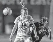  ?? ?? Johnson’s Emma Hester heads the ball in front of LEE’s Gabriella Poyo in the first half of the Jaguars’ victory at Comalander Stadium.