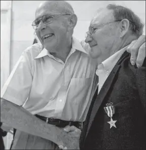  ?? Arkansas Democrat- Gazette/ BENJAMIN KRAIN ?? Dalton Zachary ( left) congratula­tes his friend James Smith in Little Rock on Tuesday after the Star City resident was awarded a Silver Star for his 1966 actions in Vietnam.