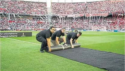  ?? (AP) ?? A juntar las alfombras. Miembros de la organizaci­ón enrollan parte de la escenograf­ía de la final de la Copa. Como en la ida igualaron 2 a 2, el que gane durante los 90 minutos se quedará con la Copa Libertador­es 2018. Si en los 90 minutos empatan, sin importar los goles, se jugarán 30 minutos de alargue. Si siguen igual, se definirá por penales.