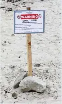  ??  ?? Warning sign to not swim erected