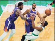  ?? Elise Amendola / Associated Press ?? Boston Celtics guard Kemba Walker shoots and scores while falling backward, next to the defense of Phoenix Suns center Deandre Ayton (22) and forward Mikal Bridges (25) in the second half on Thursday.