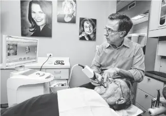  ?? ROB SCHUMACHER/THE REPUBLIC ?? Joseph Harris works on patient Mike Brannan at the Phoenix location of Harris Dental. Harris and two of his sons work together in the practice’s five Valley locations.