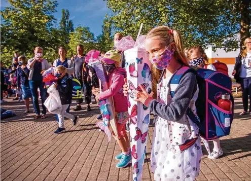  ?? FOTO: JENS BÜTTNER / DPA ?? Erster Schultag mit Mundschutz und Zuckertüte: In Mecklenbur­g-Vorpommern hat die Schule bereits begonnen.