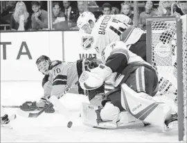  ?? Jae C. Hong Associated Press ?? DEVIN SETOGUCHI of the Kings, left, has his shot stopped by Vancouver goalie Jacob Markstrom during the second period of Saturday night’s game.