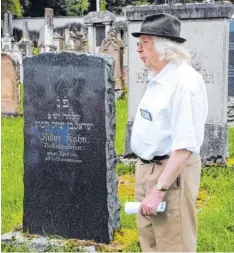  ?? Foto: Josef Osteried ?? Herbert Auer spricht über jüdische Sprachen vor einer hebräische­n Grabinschr­ift auf dem jüdischen Friedhof Krumbachs.