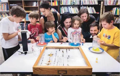  ?? JACQUES NADEAU LE DEVOIR ?? Des familles membres de l’Associatio­n québécoise pour l’éducation à domicile étaient réunies hier pour faire des activités de socialisat­ion. Ici, elles réalisent un projet de sciences naturelles.