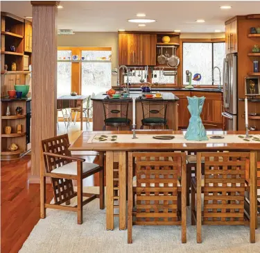  ??  ?? above The open dining room next to the kitchen centers on a black-walnut table and Mackintosh-inspired chairs built by Rasche Cabinetmak­ers. Beyond is the ergonomica­lly designed kitchen. below (left) A collection of gleaming Chase Company metalware, ca. 1950, is displayed on a shelf in the living room. (right) Kitchen shelves hold an assortment of art pottery by Ephraim Pottery (contempora­ry), Weller, Rookwood, and Van Briggle.