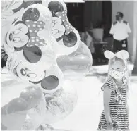  ?? STEPHEN M. DOWELL/ORLANDO SENTINEL ?? A girl gazes at balloons May 20 at Disney Springs in Orlando. Disney’s sprawling complex is beginning to get back to business.