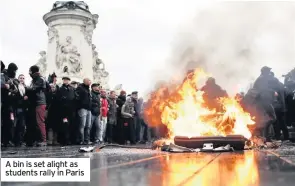  ??  ?? A bin is set alight as students rally in Paris