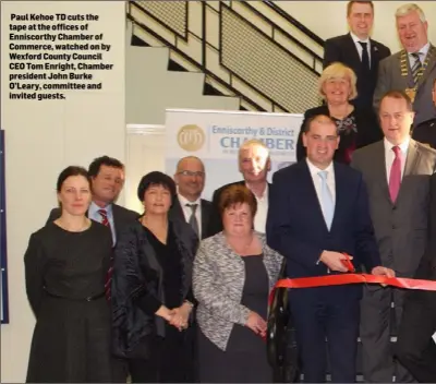  ??  ?? Paul Kehoe TD cuts the tape at the offices of Enniscorth­y Chamber of Commerce, watched on by Wexford County Council CEO Tom Enright, Chamber president John Burke O’Leary, committee and invited guests.