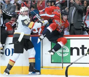  ?? AP PHOTO ?? Vegas Golden Knights forward Tomas Nosek hammers T.J. Oshie of the Washington Capitals into the boards during the second period of Wednesday night’s game in Washington.