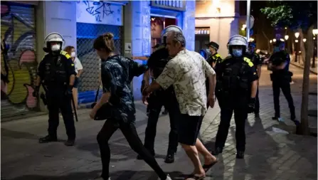  ?? JoSEP LAgo ?? Miembros de la Policía pidieron ayer a varias personas que se retiraran y se fueran a sus casas por el toque de queda, en el barrio El Born, de Barcelona, en España.