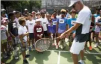  ?? MICHAEL NOBLE JR. — THE ASSOCIATED PRESS ?? John McEnroe offers tips to children ages 6 to 12 during tryouts in Harlem for the John McEnroe Tennis Academy in New York.