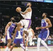  ?? Allen J. Schaben Los Angeles Times ?? LeBRON JAMES drives past Joel Embiid, right, and James Harden on his way to a first-quarter layup.