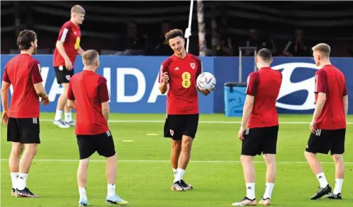  ?? (AFP) ?? Wales’ defender Ethan Ampadu (centre) chats with teammates during a training session at the Al Sadd Stadium in Doha yesterday.