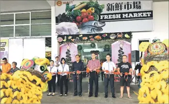  ??  ?? Jong (third left), Chan (third right), Lee (second right) and others cut the ribbon to mark the official opening of Emart Batu Kawa Fresh Market.