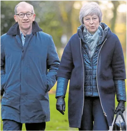  ??  ?? Theresa May and her husband Philip on their way to a church service in her Maidenhead constituen­cy yesterday