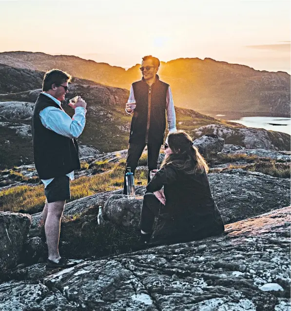  ??  ?? Friends enjoy a gin overlookin­g the Torridon Hills in the far northwest of Scotland